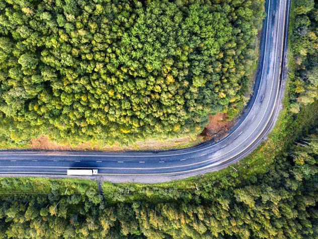 Drone view of a road, truck and trees